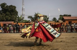 A costumed Egungun figure, revering ancestors, dances during festivities last January in Ouidah