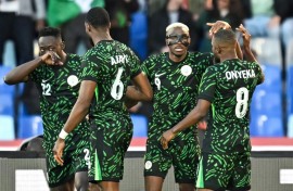 Victor Osimhen, wearing his trademark mask, celebrates after scoring Nigeria's opening goal against Algeria