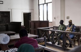 Manjang sits in the dock at the High Court in Banjul