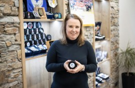 Gufex co-owner Katerina Zubickova poses with an ice hockey puck for the Milan-Cortina Olympics and Paralympics. Her firm will produce 10,000 for the competition and another 10,000 to be sold as souvenirs