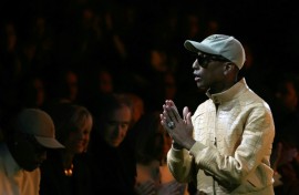US rapper and fashion designer Pharrell Williams greets the audience at the end of the Louis Vuitton show