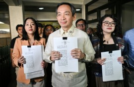 Lawmakers Sara Elago, Antonio Tinio and Louise Co show the impeachment complaint against Philippine President Ferdinand Marcos at the House of Representatives on Thursday
