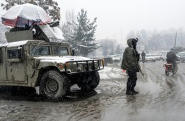 A Taliban security personnel stands guard at a checkpoint during snowfall in Kabul on January 22, 2026.