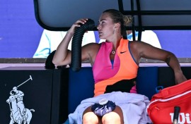Aryna Sabalenka holds an air conditioning pipe to cool down during her women's singles quarter-final
