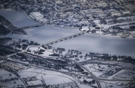 This aerial view shows a snow-covered Washington, DC, including the Lincoln Monument, the Kennedy Center, the Potomac River and the National Mall from Air Force One