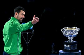 Novak Djokovic looks at the Australian Open's Norman Brookes Challenge Cup after losing in the final to Carlos Alcaraz