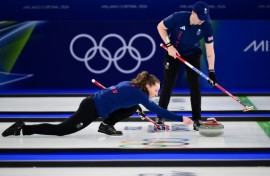 Britain's Jen Dodds aims her stone as her partner Bruce Mouat looks on during their victory in the curling mixed doubles, the opening event of the Winter Olympics