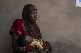 Khausara Saleem, 28, holds her three-month-old baby after fleeing the massacre in the Nigerian village of Woro