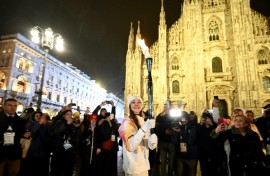 Italian ballet dancer Nicoletta Manni carries the Olympic flame in front of Milan's gothic Duomo ahead of Friday's opening ceremony