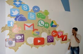 A man passes by a mural depicting various social media apps in Bangalore on March 22, 2018