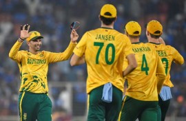 South Africa's Keshav Maharaj (L) celebrates with teammates after taking the wicket of India's Arshdeep Singh.