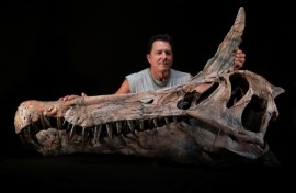 US paleontologist Paul Sereno poses next to the skull cast