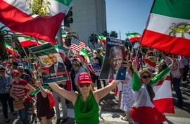 A woman holds pictures of Reza Pahlavi - the son of Iran's former Shah - and US President Donald Trump as members of the Iranian community celebrate in Los Angeles