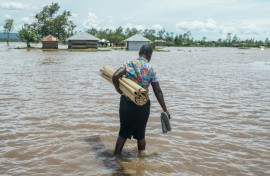 A woman in Kenya's Nyakach region wades through flooding triggered by torrential rain