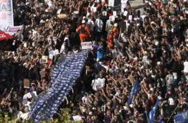 Demonstrators carry a large banner with portraits of disappeared people during a march to Plaza de Mayo