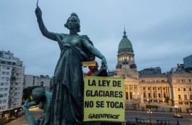 A Greenpeace activist unfurls a banner reading 'Hands off the Glaciers Law' outside Argentina's parliament ahead of a vote by MPs on an amendment watering down glacier protections
