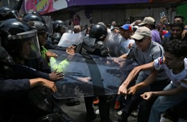 Opponents to the government of Venezuelan interim President Delcy Rodriguez clash with the police as they demonstrate in demand of salary and pension raises in Caracas on April 8, 2026