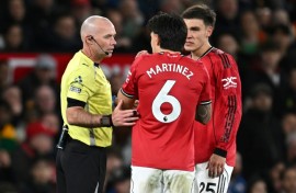 Referee Paul Tierney speaks with Manchester United defender Lisandro Martinez (C)