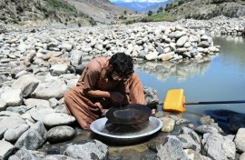 An Afghan man scours for gold using the traditional gold-panning technique allowed by authorities