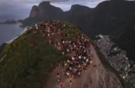 Tourists watch the sunrise from Morro Dois Irmaos above the Vidigal favela