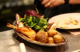 A cook prepares a rotisserie chicken with potatoes during dinner in the French restaurant Gigi’s in the Brooklyn borough of New York City on April 26, 2026