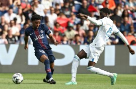 Ibrahim Mbaye (L) of Paris Saint-Germain and Abdoulaye Faye of Lorient fight for the ball.