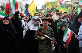 A young enthusiast in military attire holds a mock rifle during a rally to show support for Iran's new supreme leader, Ayatollah Mojataba Khamenei, in Tehran