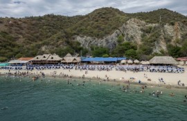 Aerial view of Playa Blanca beach in the Colombian region of Santa Marta, where mountains sweep down through jungle to the Caribbean