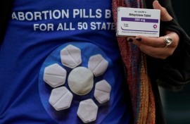 An abortion rights activist holds a box of mifepristone during a rally in front of the US Supreme Court on March 26, 2024, in Washington, DC