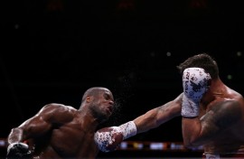 Daniel Dubois (L) takes a punch from champion Oleksandr Usyk during an undisputed world heavyweight title bout at London's Wembley Stadium in July last year