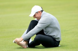 Second-ranked Rory McIlroy of Northern Ireland checks on a blister on his right pinky toe on the 18th hole during a practice round on the eve of the opening round of the PGA Championship at Aronimink
