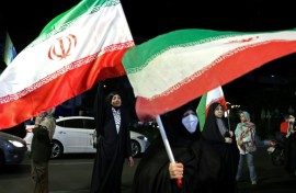 Women hold Iran's national flags during an anti-US and Israel protest in Tehran