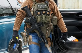 A masked federal agent from Immigration and Customs Enforcement (ICE) patrols in Minneapolis, Minnesota, in February 2026