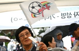 A South Korean football supporter waves a flag of North Korean team Naegohyang Women's FC