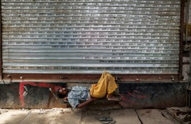 A man takes a nap in front of a closed shop on a hot summer day in Varanasi, in India's Uttar Pradesh, on May 23, 2026
