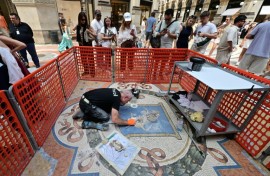 Restorer Gianluca Galli works on the mosaic of the bull during the restoration in the Galleria Vittorio Emanuele II