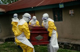 Members of a Congolese Red Cross team carry the coffin of a woman suspected of having died from Ebola in the eastern city of Bunia