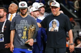 Jalen Brunson of the New York Knicks accepted the Bill Russell NBA Finals Most Valuable Player Award trophy with his father at his side
