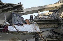 A woman gestures for help atop an apartment building following the earthquakes that hit Venezuela's La Guaira state particularly hard