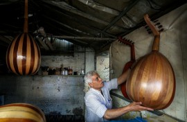Displaced Palestinian craftsman Suhail Abu Shawish repairs damaged Ouds at a workship in Nuseirat refugee camp in Gaza