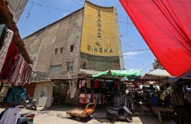 Street vendors gather outside the faded facade of the Granada Cinema, an early 1940s landmark, in the Bab al-Sharqi district of central Baghdad