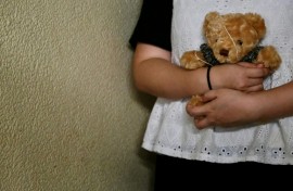 Bobo a woman who suffered persistent child sexual abuse for several years, holds a teddy bear