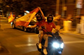 Spain supporters on a motorcycle wave the flag celebrating victory after the 2026 World Cup final