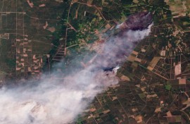 This handout satellite photograph taken on July 24, 2026 and released by 2026 Planet Labs PBC shows smoke rising from the wildfire in Le Porge and Lege-Cap-Ferret in France