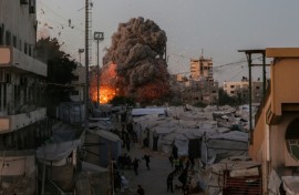 Palestinians run for cover as smoke and fire rise during an Israeli strike on the the Al-Muttaqin Mosque in Gaza City on July 28, 2026