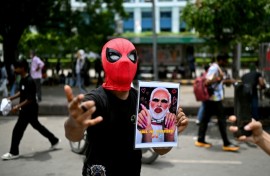 A Cockroach Janta Party supporter holds a doctored picture of India's Prime Minister Narendra Modi at a rally in New Delhi on July 25. Modi said he wanted to "forgive" protesters who abused him
