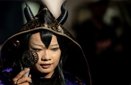 A cosplayer uses a portable fan to cool down while visiting the Osu Shopping Street before the Osu Cosplay Parade, during the second day of the World Cosplay Summit 2026 in Nagoya on August 1, 2026.