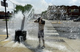 A person cools off with water from an open fire hydrant during a heat wave on the West Side of Chicago, Illinois, on July 2, 2026