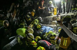 Firefighters and rescue teams carry survivor Daniela Largo from the rubble of a collapsed building after an earthquake in Pereira, Colombia