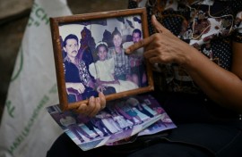Marlene Nino points to an old photo of her sister Doris, who was killed when her building collapsed in the 7.4 magnitude earthquake in Cali, Colombia